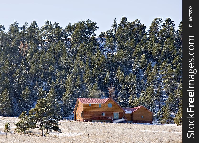 Wood cabin in the hills in the winter with snow on the ground