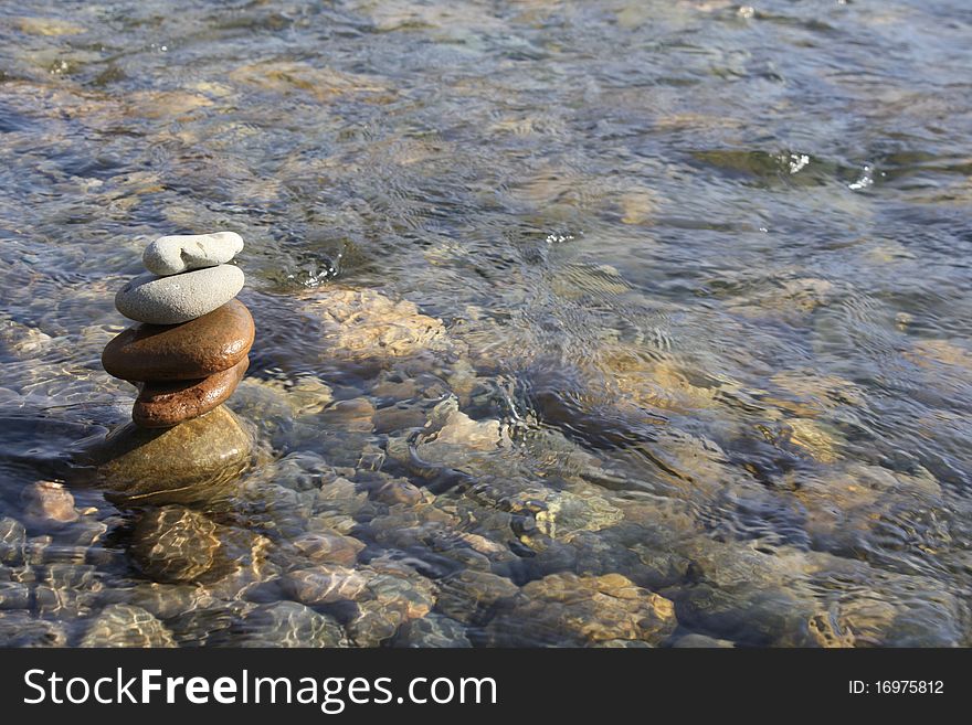 A pile of stones in a river. A pile of stones in a river