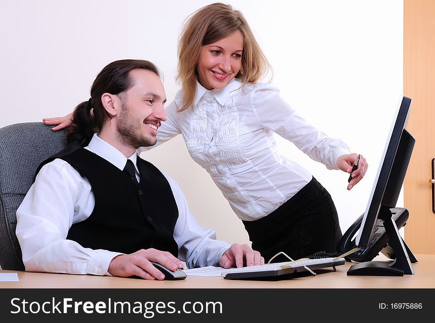 A young business man and a girl running on the computer in the office.