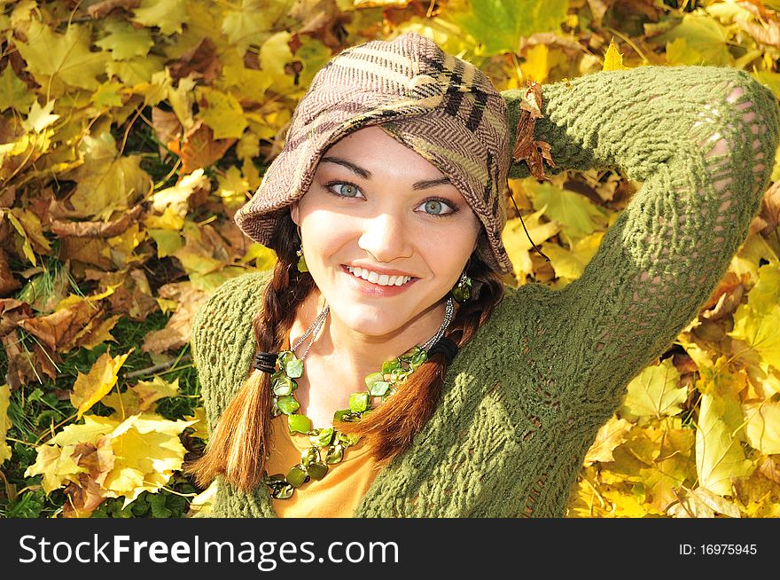 Beautiful young woman lying in yellow autumn leaves. Beautiful young woman lying in yellow autumn leaves