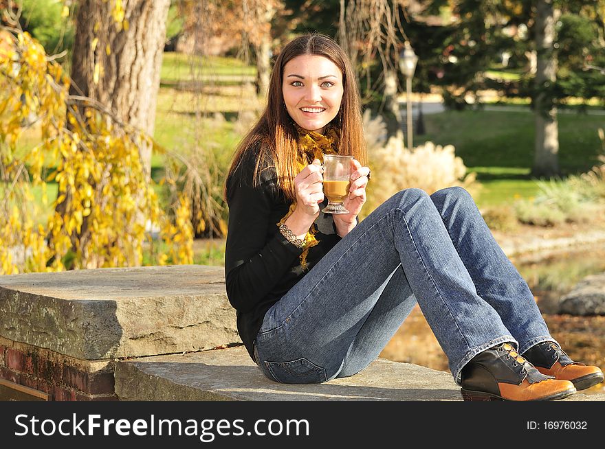 Young woman sipping coffee out on a bright fall day. Young woman sipping coffee out on a bright fall day