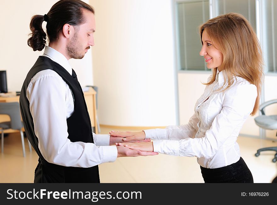 A young girl claps her hands to his colleague in the office.