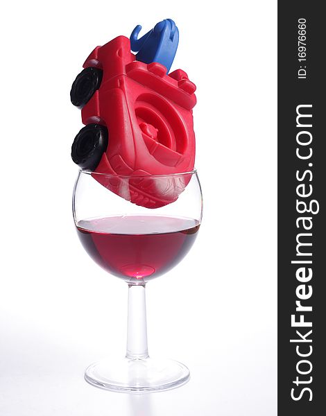 Toy truck placed inside a glass of red wine. Toy truck placed inside a glass of red wine