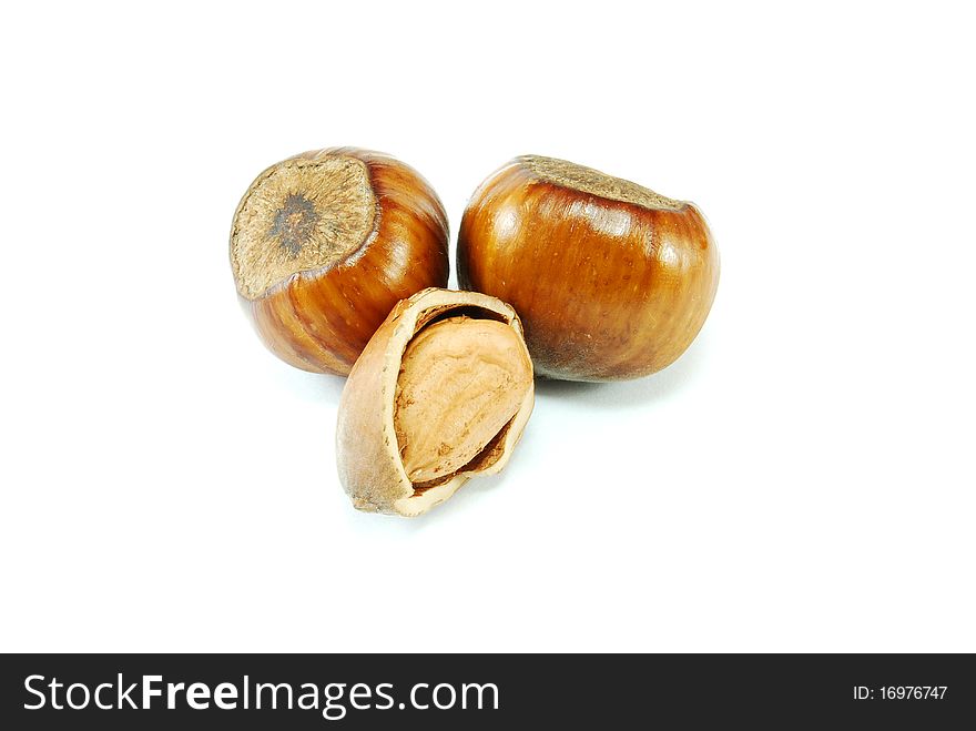 Brown cracked hazelnuts isolated on white