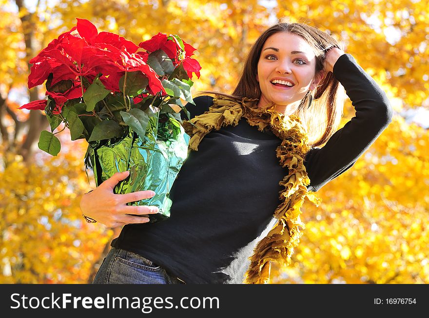 Happy girl holding a poinsettia flower arrangement. Happy girl holding a poinsettia flower arrangement