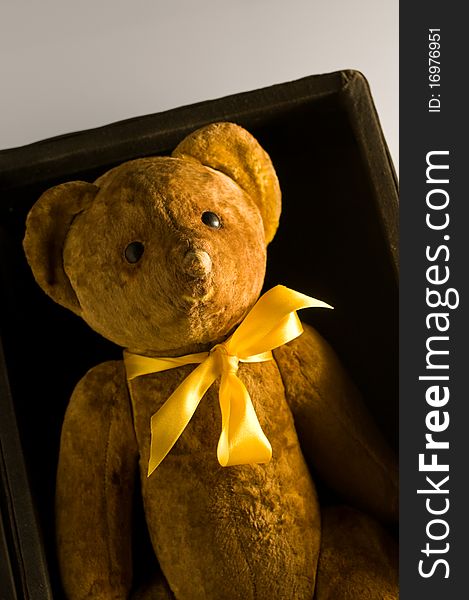 A old teddy bear in box