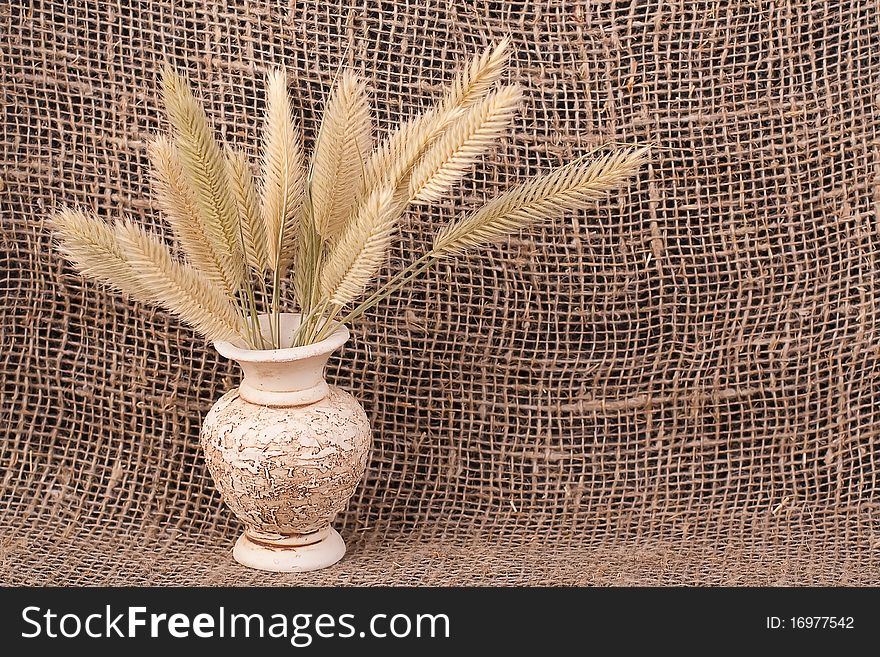 Jug with ears background  of rough material