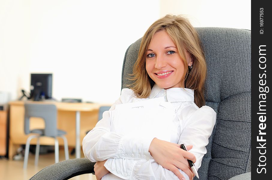 A young girl in his office sits in a gray chair.