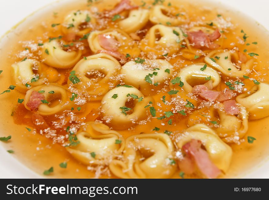 Food styling of Tortellini soup with ham and herbs