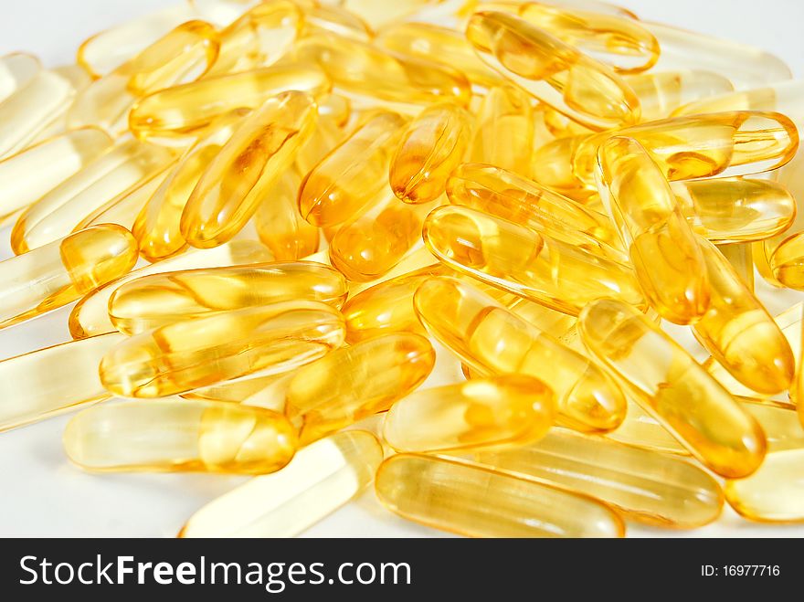 Pile of shiny yellow capsule vitamin background