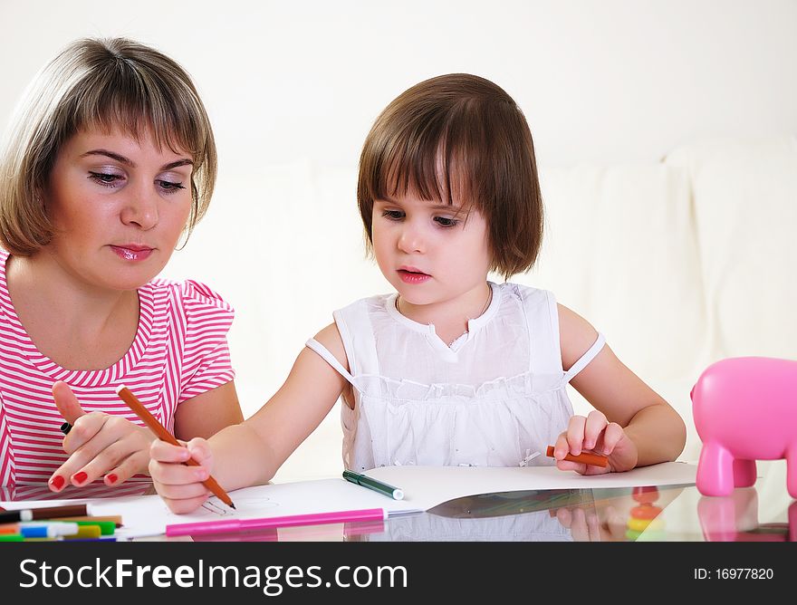 Mother and daughter together paint an album and have fun together.