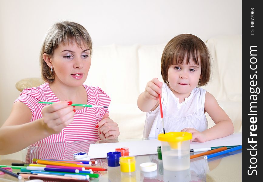 Mother and daughter together paint an album and have fun together.