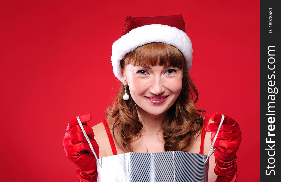 A young girl dressed as Santa Claus on a red background