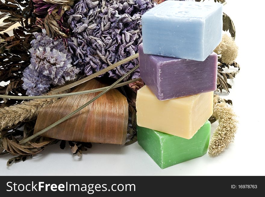 Dried flowers and colorful soap on a white background