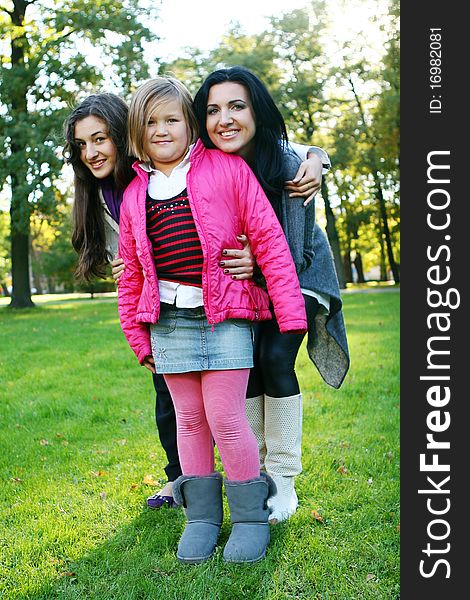 Young family taking healthy stroll through autumn park and have fun. Young family taking healthy stroll through autumn park and have fun