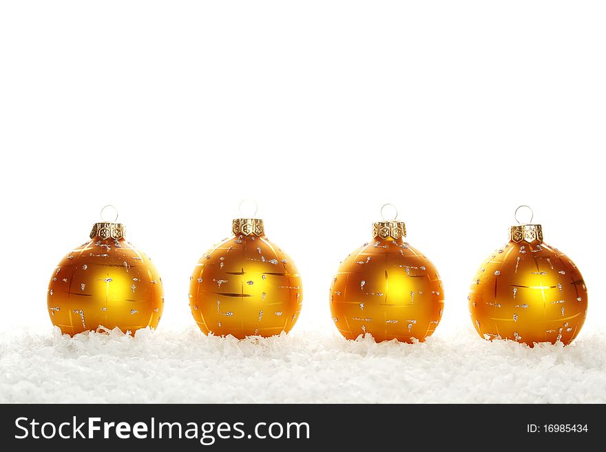 Four yellow (gold) Christmas ball in the series lie in the snow. Isolated on white background. Four yellow (gold) Christmas ball in the series lie in the snow. Isolated on white background