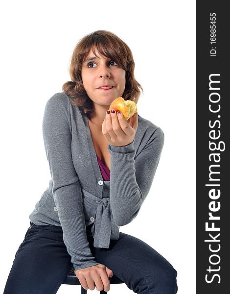 Beautiful teenager eating an apple in front of a white background. Beautiful teenager eating an apple in front of a white background