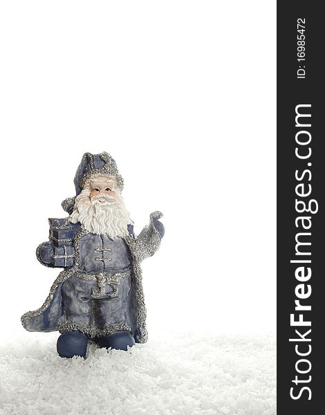 Blue Santa Claus figurine stands on an artificial snow. Isolated on a white background. Blue Santa Claus figurine stands on an artificial snow. Isolated on a white background