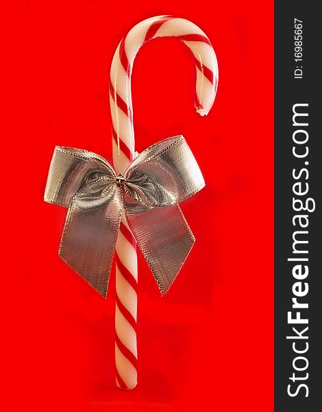 Candy cane with a silver bow over red