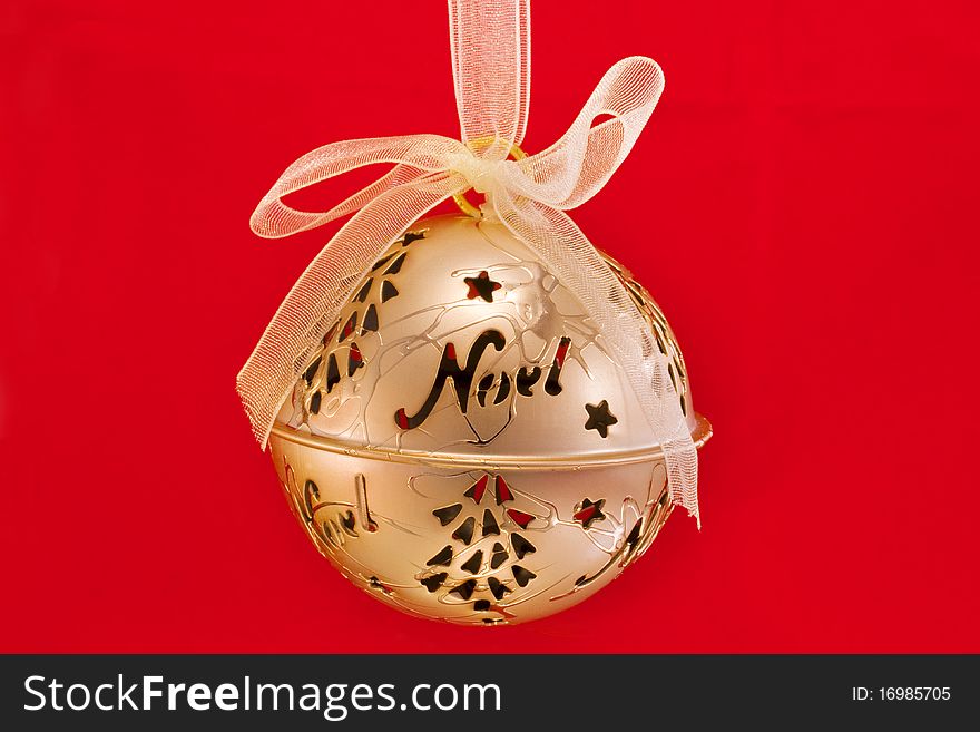 Gold bauble isolated on a red background. Gold bauble isolated on a red background