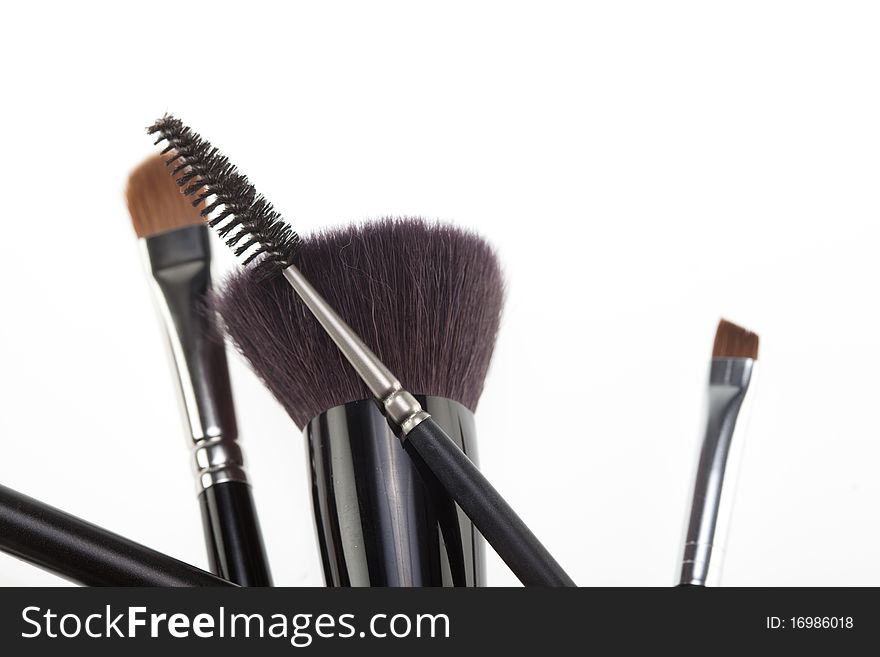 A detail of a make-up brushes composition, in a random position, shot on white background. A detail of a make-up brushes composition, in a random position, shot on white background.