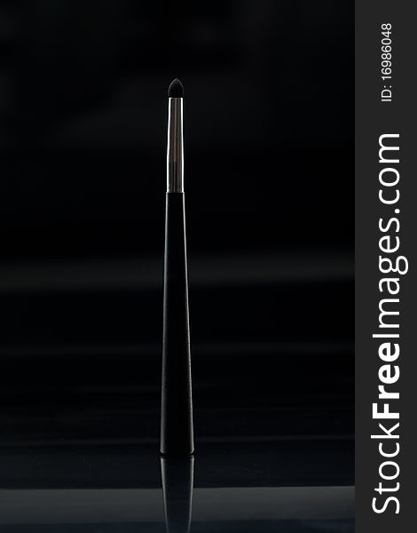 A sponge eye shadow applicator, in a vertical position, shot on black background, with a reflexion. A sponge eye shadow applicator, in a vertical position, shot on black background, with a reflexion.