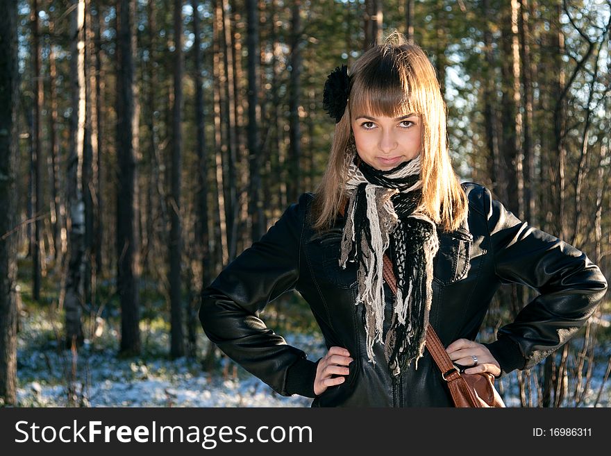 Young beautiful girl in black jacket in wood