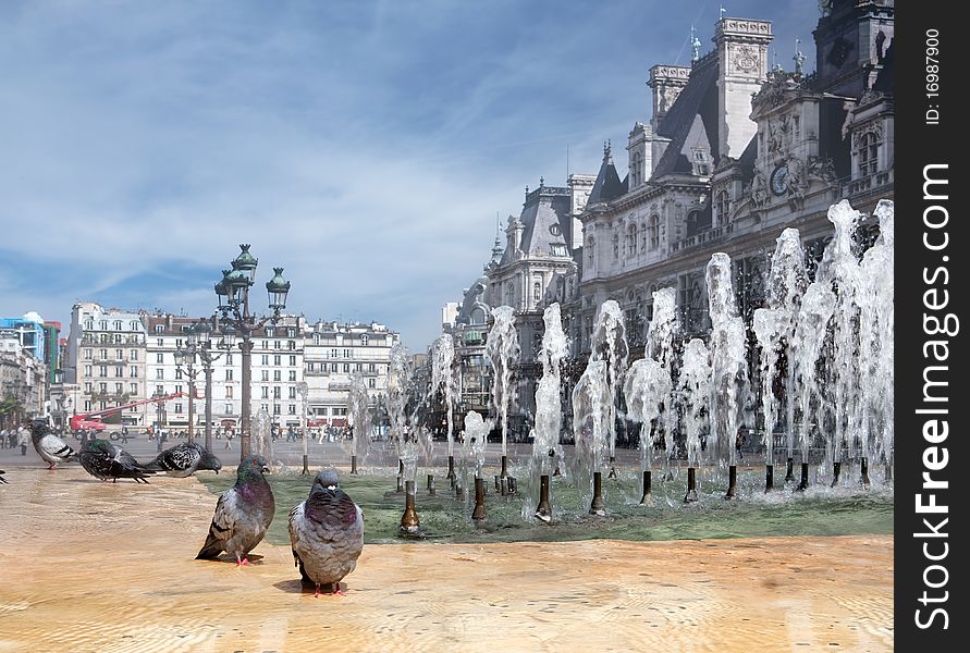Kind on a fountain with pigeons against the mayoralty in Paris.