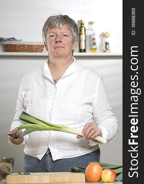 Women is cutting leek in the kitchen