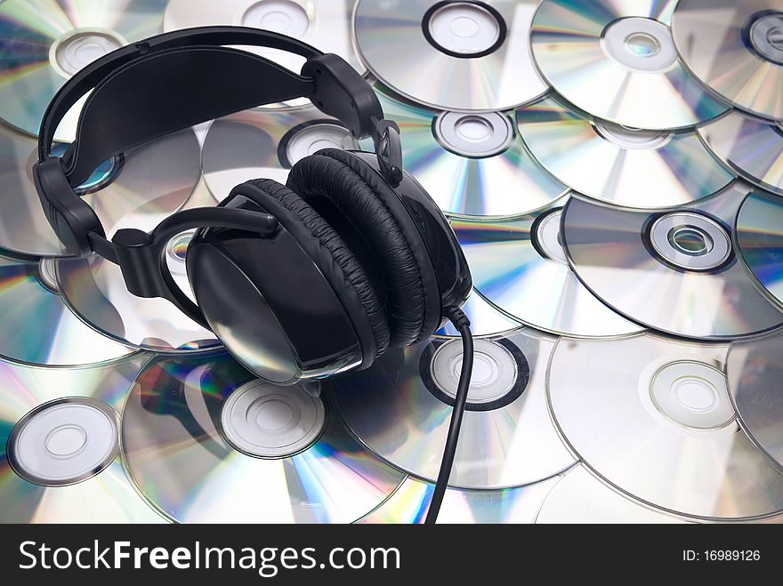 Black headphones on cd background. Studio shot. Black headphones on cd background. Studio shot