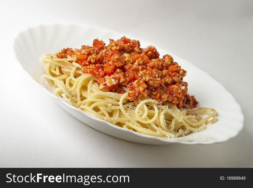 Spaghetti a la Bolognese in the white plate over grey gradient background