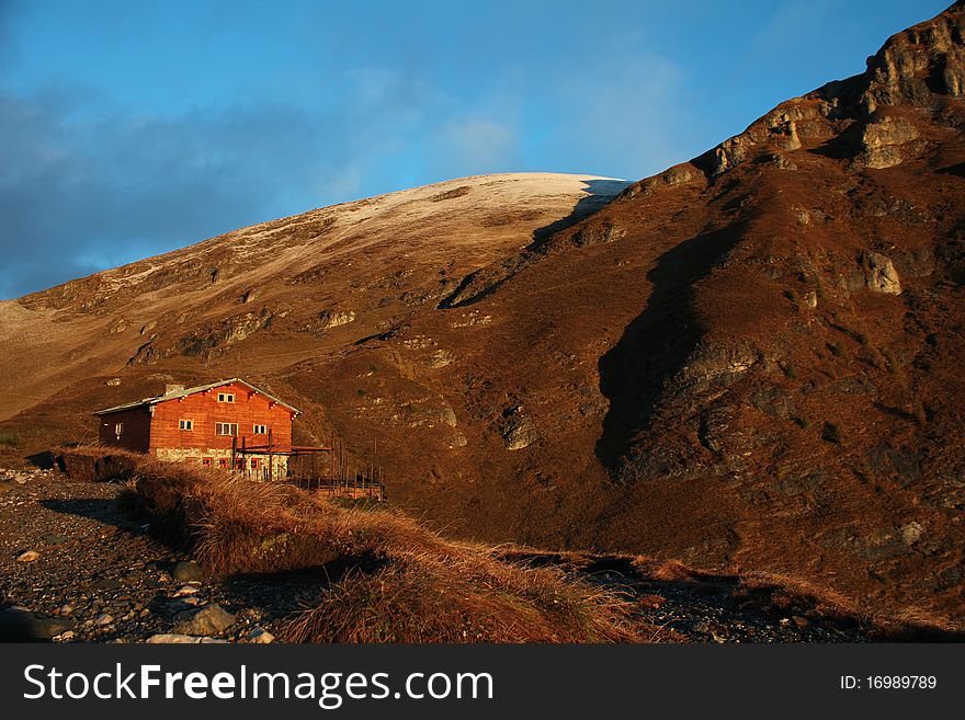 Old wood chalet in the mountains, in the sunrise light.