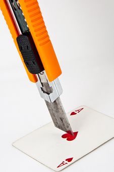 Utility Knife Pointing At A Playing Card Royalty Free Stock Photo