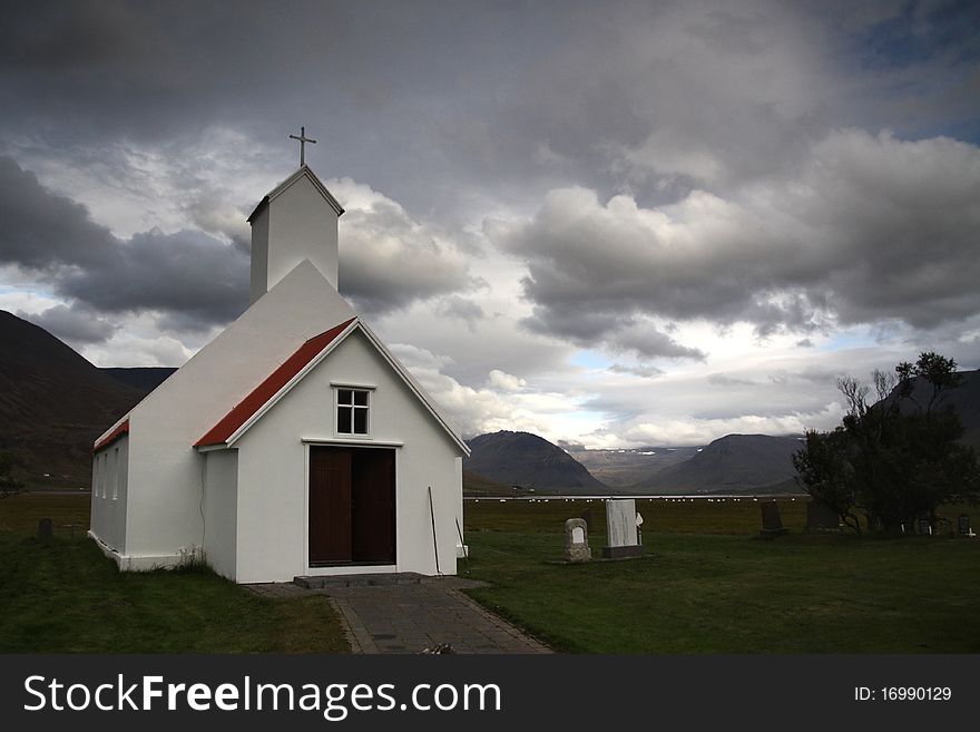 Typical White Icelandic Wooden Church with grey clouds in the back. Typical White Icelandic Wooden Church with grey clouds in the back
