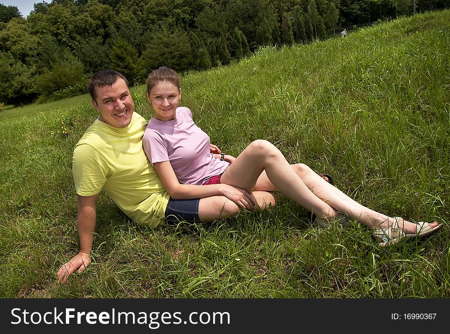 Young couple lying on the grass in the summer park