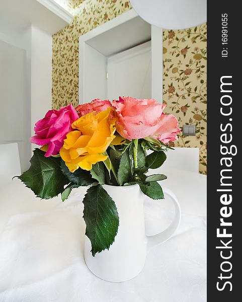 Colored roses in white vase, close-up photo