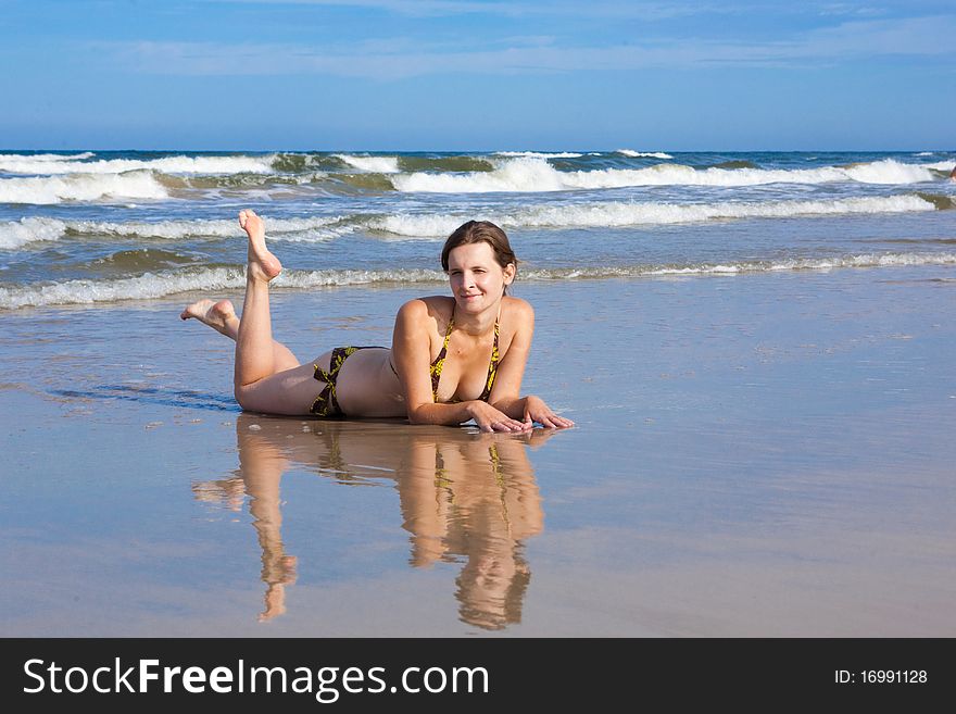 Young woman lying on the sand near the sea. Young woman lying on the sand near the sea