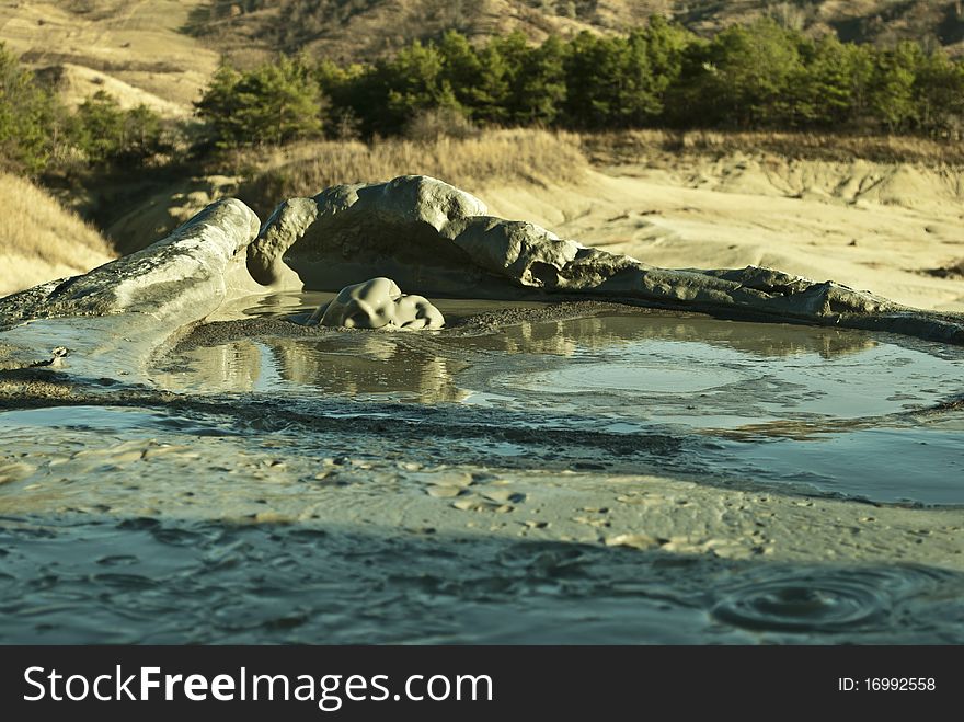 The Berca Mud Volcanoes are a geological and botanical reservation located in the Berca commune in the BuzÄƒu County in Romania. Its most spectacular feature is the mud volcanoes, small volcano-shaped structures typically a few meters high caused by the eruption of mud and natural gases.