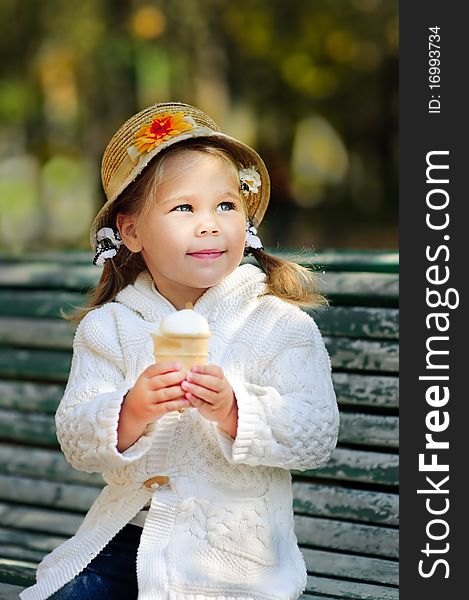 Portrait of small thinking girl with ice cream in autumn park. Portrait of small thinking girl with ice cream in autumn park