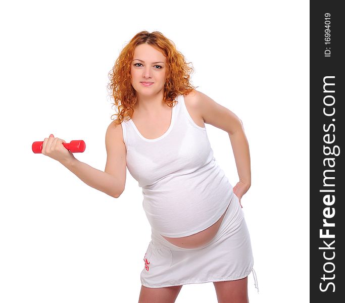 Young red-haired pregnant girl is engaged in sports.