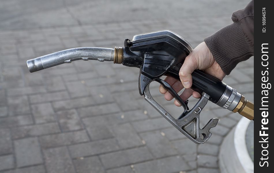 To draw petrol. Hand holding petrol pump. To draw petrol. Hand holding petrol pump