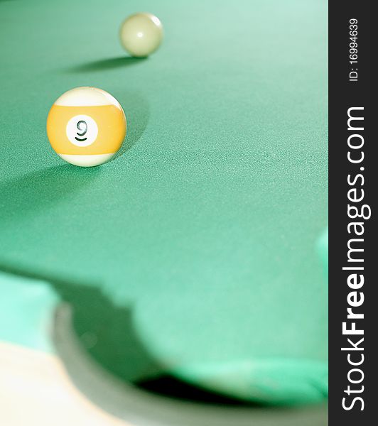 Billiard ball near hole, a lot of balls in blurry background. Billiard ball near hole, a lot of balls in blurry background