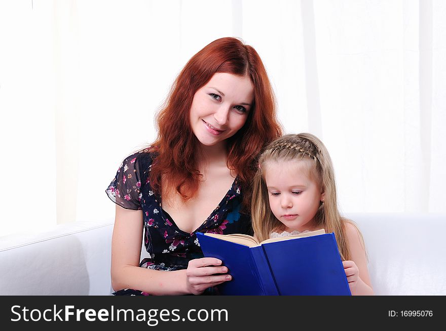 Little girl and her mother read a book