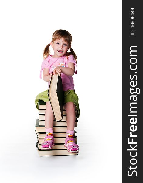 Cute little girl sit on a stack of big books on white background. Cute little girl sit on a stack of big books on white background