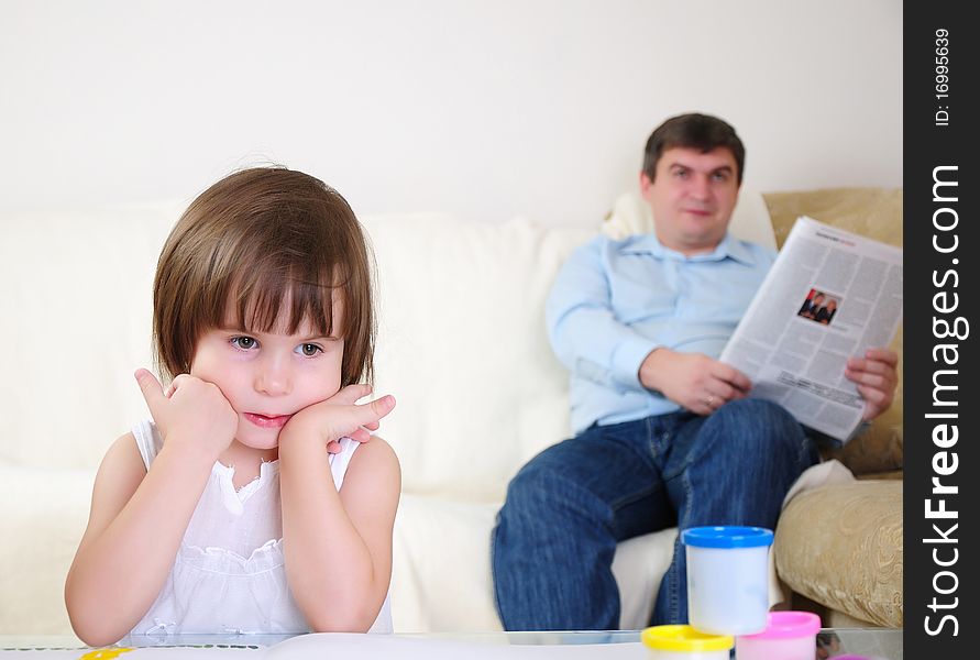 A little girl alone draws on the album.