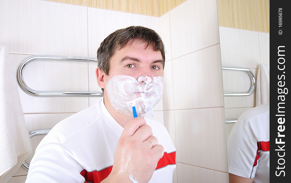 Father causes the foam to the face for shaving in the bathroom