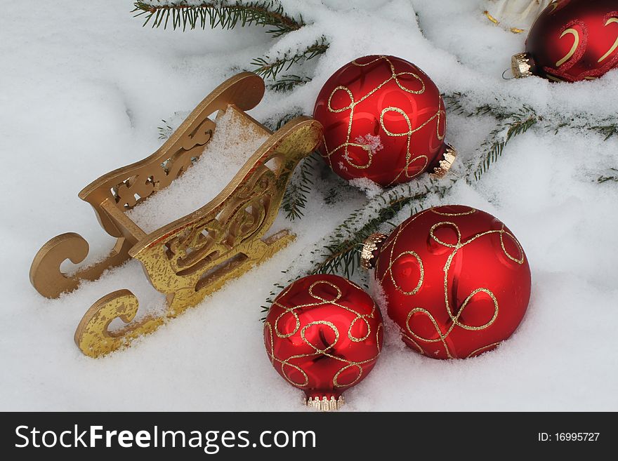 Red Christmas balls with sledge in snow