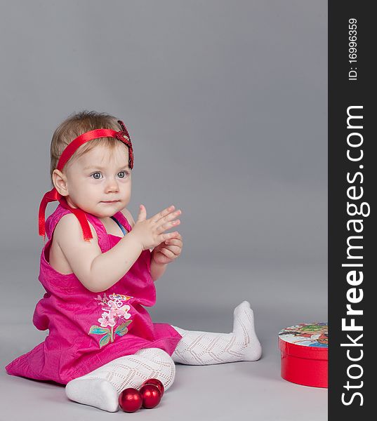 Little girl is playing with Christmas balls