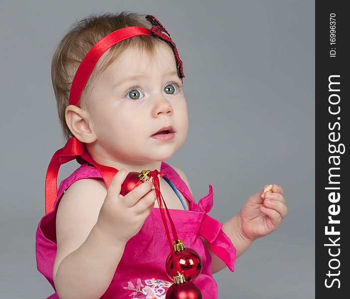 Little girl is playing with Christmas balls