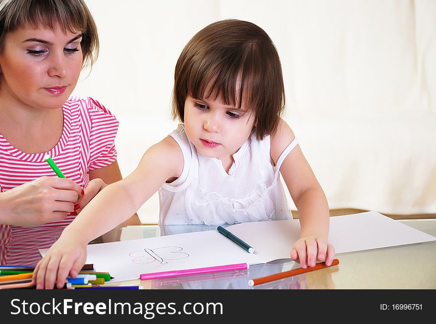 Mother and daughter together paint an album and have fun together.